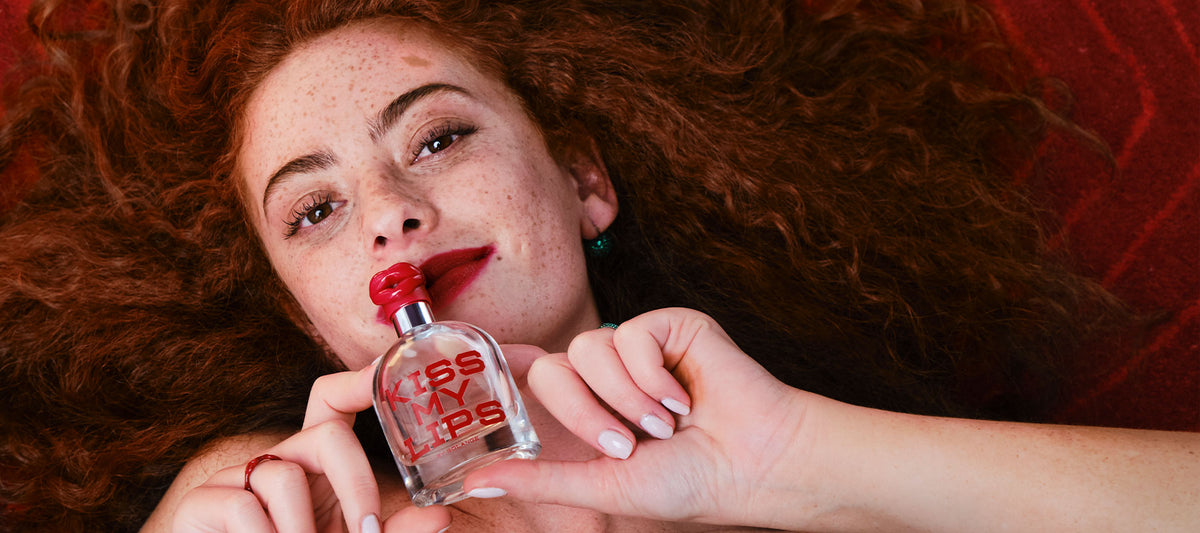 woman holding Kiss My Lips bottle