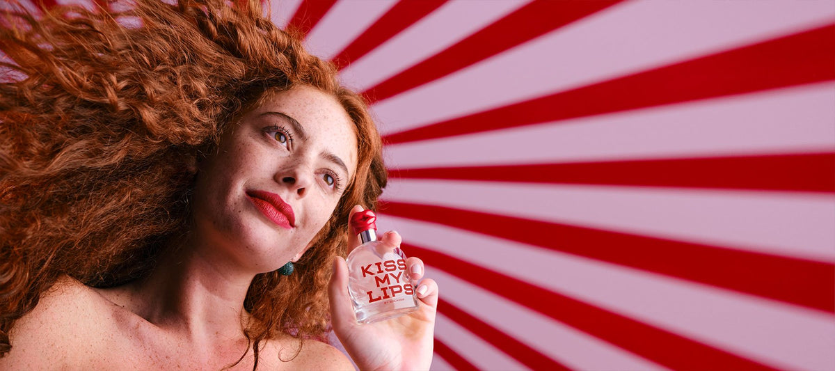 woman holding Kiss My Lips bottle